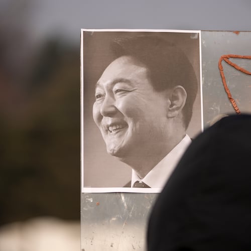 A picture of former South Korean President Yoon Suk Yeol is placed on a board as supporters gather outside Seoul Central District Court, in Seoul, South Korea, Friday, Jan. 16, 2026. (AP Photo/Lee Jin-man)
