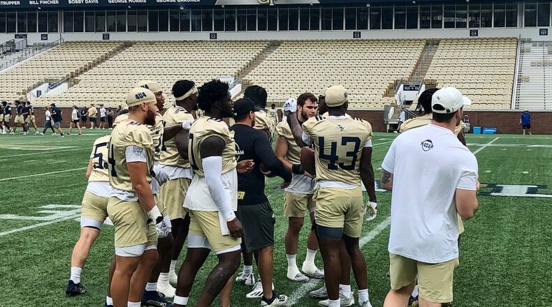 Georgia Tech linebackers break a huddle during their practice at Bobby Dodd Stadium Aug. 19, 2022. Position coach Jason Semore (black t-shirt) is in the middle of the huddle. (AJC photo by Ken Sugiura)