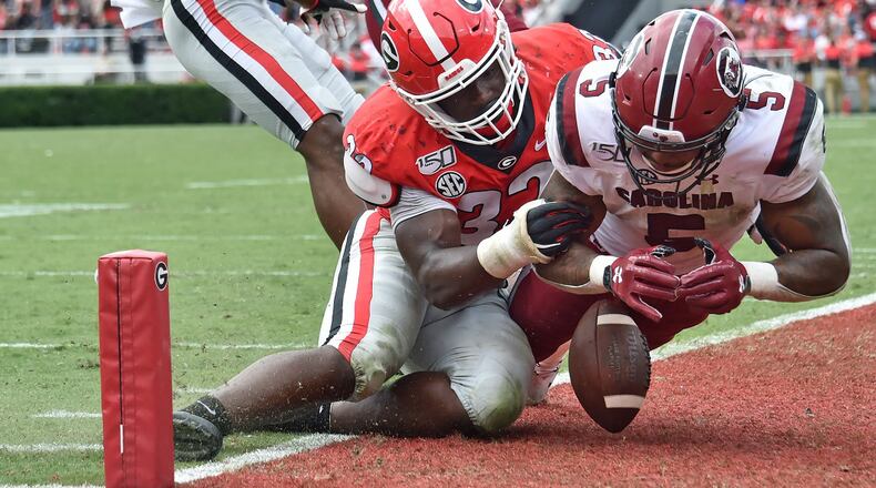 Georgia linebacker Monty Rice (32) stops South Carolina running back Rico Dowdle (5) as he dives into the end zone in overtime at Sanford Stadium in Athens on Saturday, October 12, 2019. (Hyosub Shin / Hyosub.Shin@ajc.com)