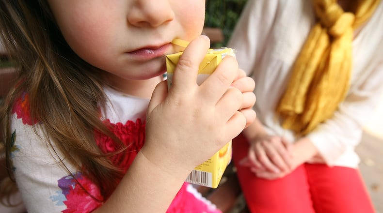 BERLIN, GERMANY - SEPTEMBER 16: A mother sits next to her three-year-old daughter on a park bench as the girl drinks orange juice on September 16, 2012 in Berlin, Germany. Germany is currently debating the introduction of a nation-wide home child care subsidy (Betreuungsgeld), which would provide parents of one to three-year-old children the option of receiving EUR 150 (196.91 USD) a month to care for the child at home rather than sending him or her to a daycare center. Critics argue it would prevent the integration of children of recent immigrants into German society. (Photo by Adam Berry/Getty Images)
