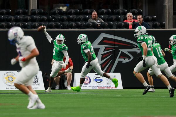 Roswell defensive lineman Jaxon Holly (9, second from left) reacts after returning an interception for a touchdown during the first half against Walton in a GHSA football game in the Corky Kell + Dave Hunter Classic at Mercedes-Benz Stadium, Thursday, August 13, 2026, in Atlanta. (Jason Getz/AJC)