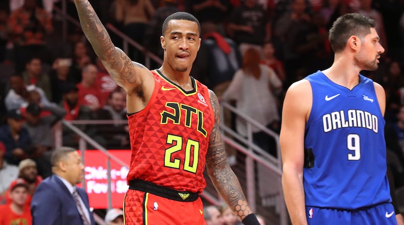 In his role as emotional spark plug, Hawks forward John Collins encourages the fans during the team's home opener against Orlando. (Curtis Compton/ccompton@ajc.com)