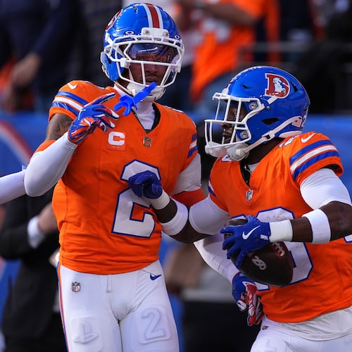Denver Broncos cornerback Ja'quan McMillian, right, celebrates with cornerback Pat Surtain II (2) after scoring a touchdown on an interception against the Los Angeles Chargers in the first half of an NFL football game Sunday, Jan. 4, 2026, in Denver. (AP Photo/David Zalubowski)