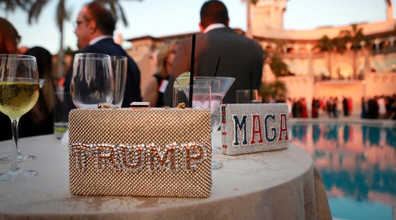 "Trump" and "MAGA" purses sit on a poolside table as guests gather before the start of the Republican Party of Palm Beach County's Lincoln Day Dinner at Mar-a-Lago in Palm Beach, Florida on Friday, March 16, 2018. (Bruce R. Bennett/The Palm Beach Post/TNS)