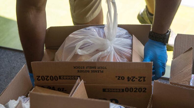 04/09/2020 - Atlanta, Georgia  - Gloves were worn by the individuals placing food in the cars of the families in need during an Atlanta Community Food Bank and Fulton County Schools collaborative distribution at Elizabeth Baptist Church in Atlanta, Thursday, April 9, 2020.  (ALYSSA POINTER / ALYSSA.POINTER@AJC.COM)