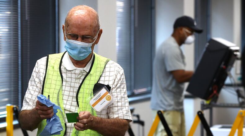 Election worker Lamar Wood cleans and disinfects voting cards and styluses between voters Monday at the Cobb County Board of Elections and Registration in Marietta. It was the first day of early voting for the June 9 Georgia primary. Curtis Compton ccompton@ajc.com