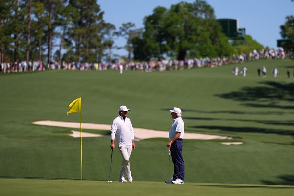Brooks Koepka, left, and Fred Couples speak on the 10th green during a practice round at the Masters golf tournament, Tuesday, April 8, 2025, in Augusta, Ga. (AP Photo/Matt Slocum)