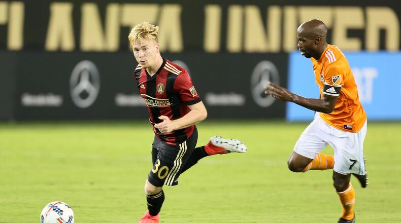 Atlanta born Andrew Carleton tries to avoid Houston Dynamo defender DaMarcus Baesley.