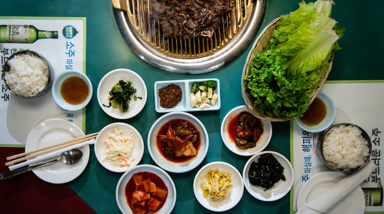 Here’s a typical meal at Hae Woon Dae on Buford Highway. On the grill is bulgogi (top), the classic marinated beef shortrib common in Korean cuisine. Below it is a selection of typical banchan, all made in-house at Hae Woon Dae. CONTRIBUTED BY HENRI HOLLIS