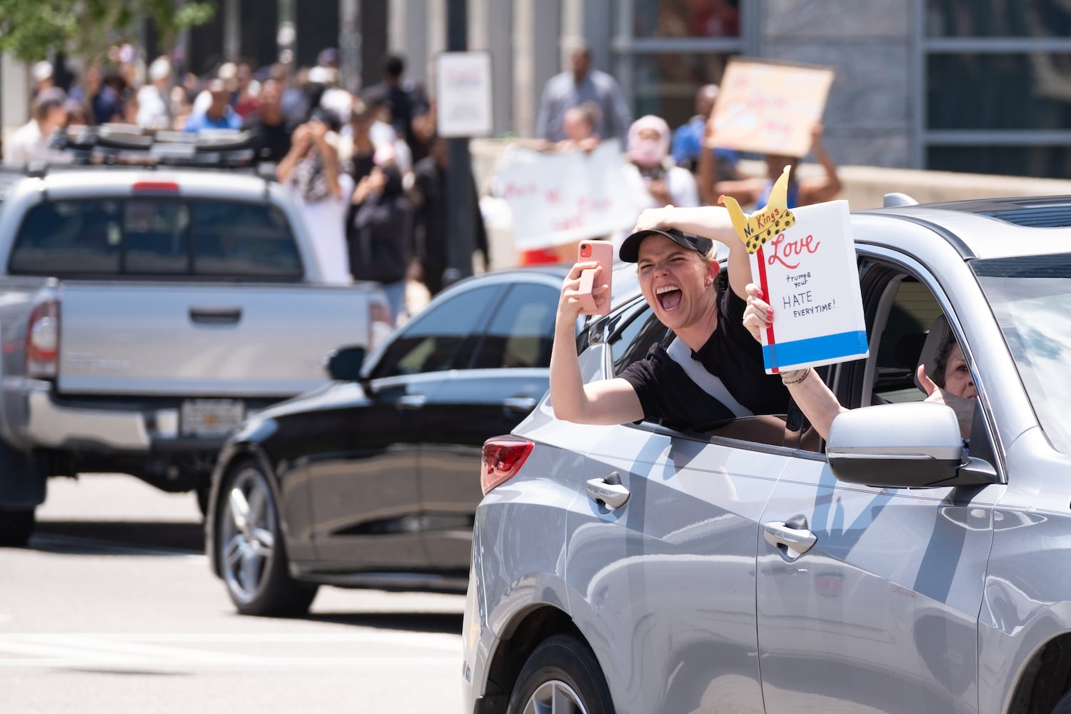 A supporter drives across the 17th Street bridge in Atlanta while people protest as part of the nation-wide No Kings protests Saturday, June 14, 2025.   Ben Gray for the Atlanta Journal-Constitution