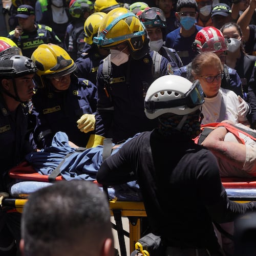 Rescue workers carry Diana Troncoso after pulling her from the rubble the day after an earthquake struck Cali, Colombia, Tuesday, Aug. 11, 2026. (AP Photo/Ivan Valencia) CORRECTION: Changes city to Cali, not Pereira.