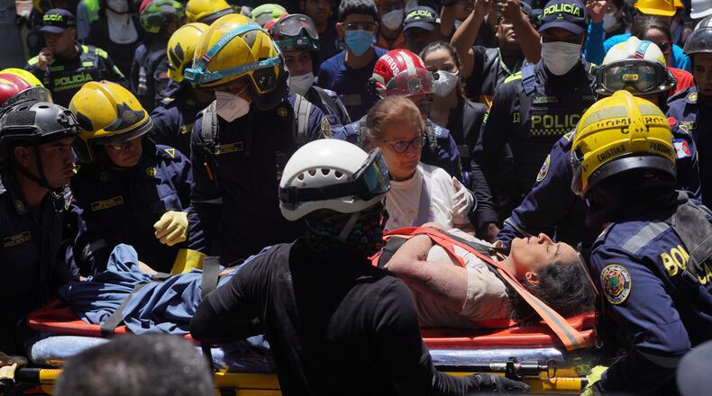Rescue workers carry Diana Troncoso after pulling her from the rubble the day after an earthquake struck Cali, Colombia, Tuesday, Aug. 11, 2026. (AP Photo/Ivan Valencia) CORRECTION: Changes city to Cali, not Pereira.