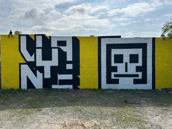 The Art Share Foundation commissioned this mural by Atlanta artists Vayne and Evereman on the back of the Eyedrum art and music gallery at 515 Ralph David Abernathy Blvd. SW (at Humphries Street). The artists are shown sitting on the wall above their respective works. (Courtesy of The Art Share Foundation)