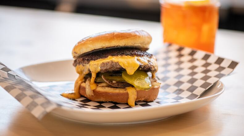 The Abby Singer Jucy Lucy is a half-pound of all-natural beef burger with molten American cheese, caramelized onions, and dill pickle chips. (Mia Yakel for The Atlanta Journal-Constitution)