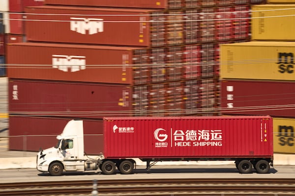 A truck carrying a Hede (Hong Kong) International Shipping Co., Ltd., container moves along the Port of Los Angeles Wednesday, April 9, 2025 in Los Angeles. (AP Photo/Damian Dovarganes)