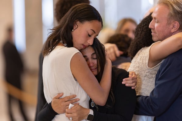 Alessa and Abigale Love hug attendees who came to pay their respects during a funeral service for former U.S. Rep. Mia Love, Sunday, April 6, 2025, in Salt Lake City. (AP Photo/Melissa Majchrzak)
