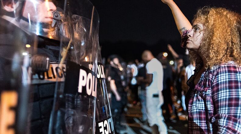 CHARLOTTE, NC – SEPTEMBER 21: Police officers face off with protestors on the I-85 (Interstate 85) during protests following the death of a man shot by a police officer on September 21, 2016 in Charlotte, NC. The protests began the previous night following the fatal shooting of 43-year-old Keith Lamont Scott at an apartment complex near UNC Charlotte. (Photo by Sean Rayford/Getty Images)