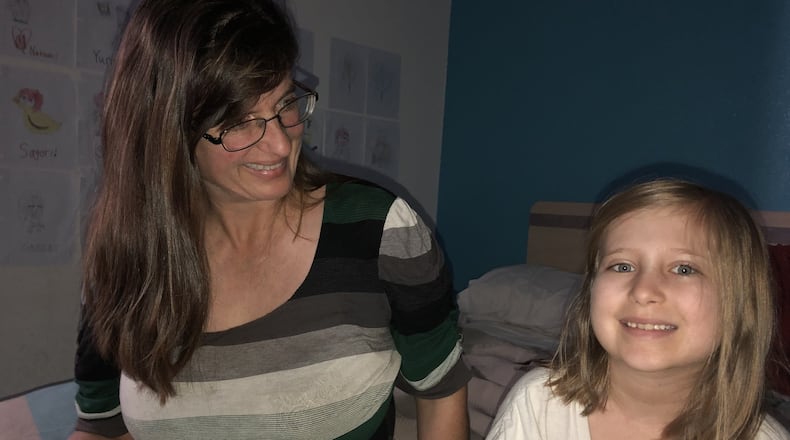 Rimbey Schroeder shares a moment with the youngest of her three daughters in their room at a Motel 6 in Norcross. GRACIE BONDS STAPLES / GSTAPLES@AJC.COM