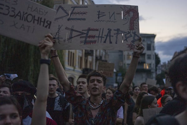 Man chants and holds banner reading "Where are you and where are the people?" during a protest against a law targeting anti-corruption institutions in central Kyiv, Ukraine, Tuesday, July 22, 2025. (AP Photo/Alex Babenko)