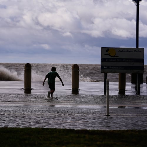Josiah Carpenter, 8, frolics in the floodwaters on Lakeshore Drive along Lake Pontchartrain as Tropical Storm Bertha approaches the Louisiana Coast Wednesday, July 22, 2026, in New Orleans. (AP Photo/Gerald Herbert)