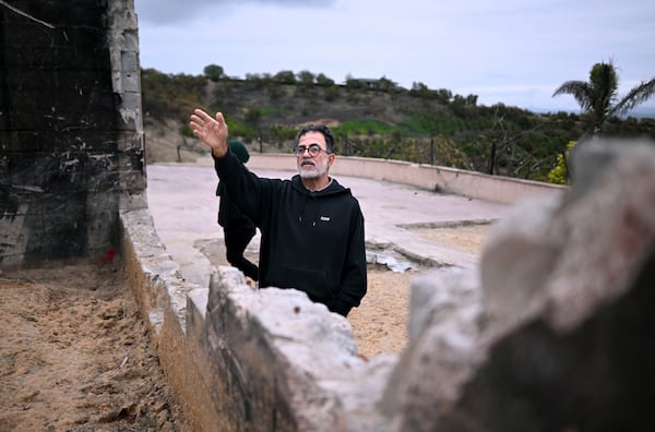 Hatim Naim and his wife Samah walk in the ruins of their property which burned in the Mountain Fire Wednesday, April 16, 2025, in Somis, Calif. (AP Photo/Wally Skalij)