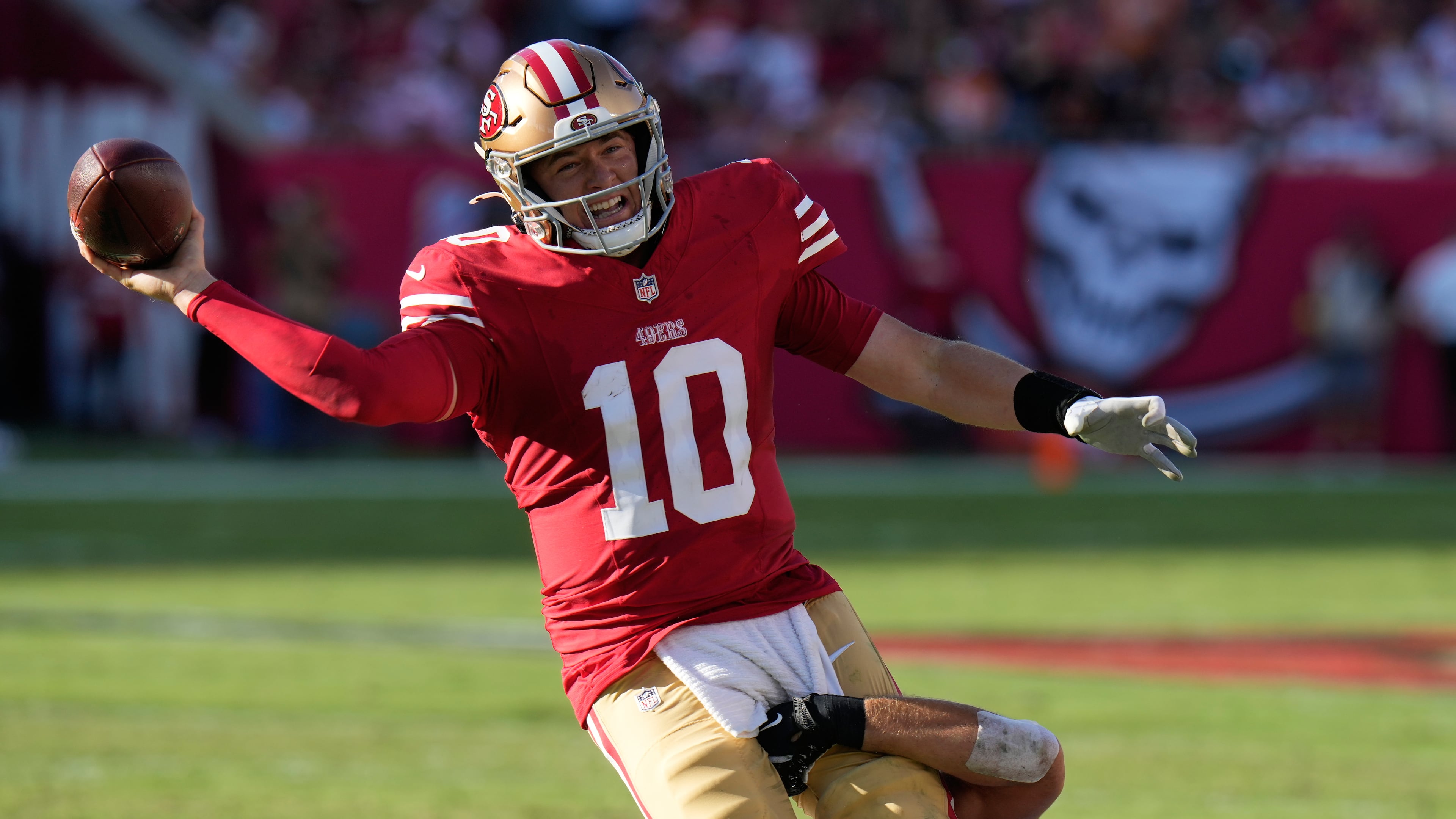 San Francisco 49ers quarterback Mac Jones (10) passes the ball over Tampa Bay Buccaneers linebacker Anthony Nelson, bottom, during the first half of an NFL football game in Tampa, Fla., Sunday, Oct. 12, 2025. (AP Photo/Chris O'Meara)