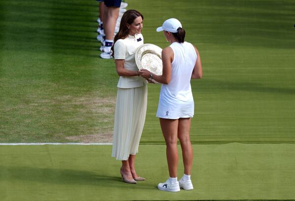 Britain's Kate, Princess of Wales presents the Venus Rosewater Dish to Iga Swiatek, following her victory over Amanda Anisimova in the Ladies' Singles Final at the Wimbledon Tennis Championships in London, Saturday, July 12, 2025. (Ben Whitley/PA via AP)