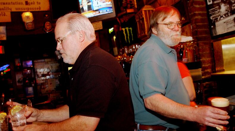 Bobby Agee (left) and Bill McCloskey serve customers at Manuel's Tavern in 2005. McCloskey, a fixture at Manuel’s for nearly 50 years, died Sunday, July 14, 2019.