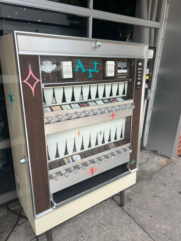 Lenny's Hair Salon in Marietta Square has an art vending machine sitting outside his salon with local art. (Olivia Wakim / AJC)