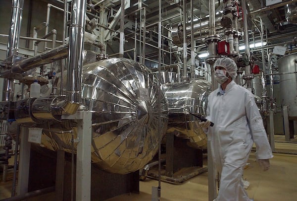 FILE - An Iranian security official in protective clothing walks through part of the Uranium Conversion Facility just outside the Iranian city of Isfahan, March 30, 2005. (AP Photo/Vahid Salemi, File)