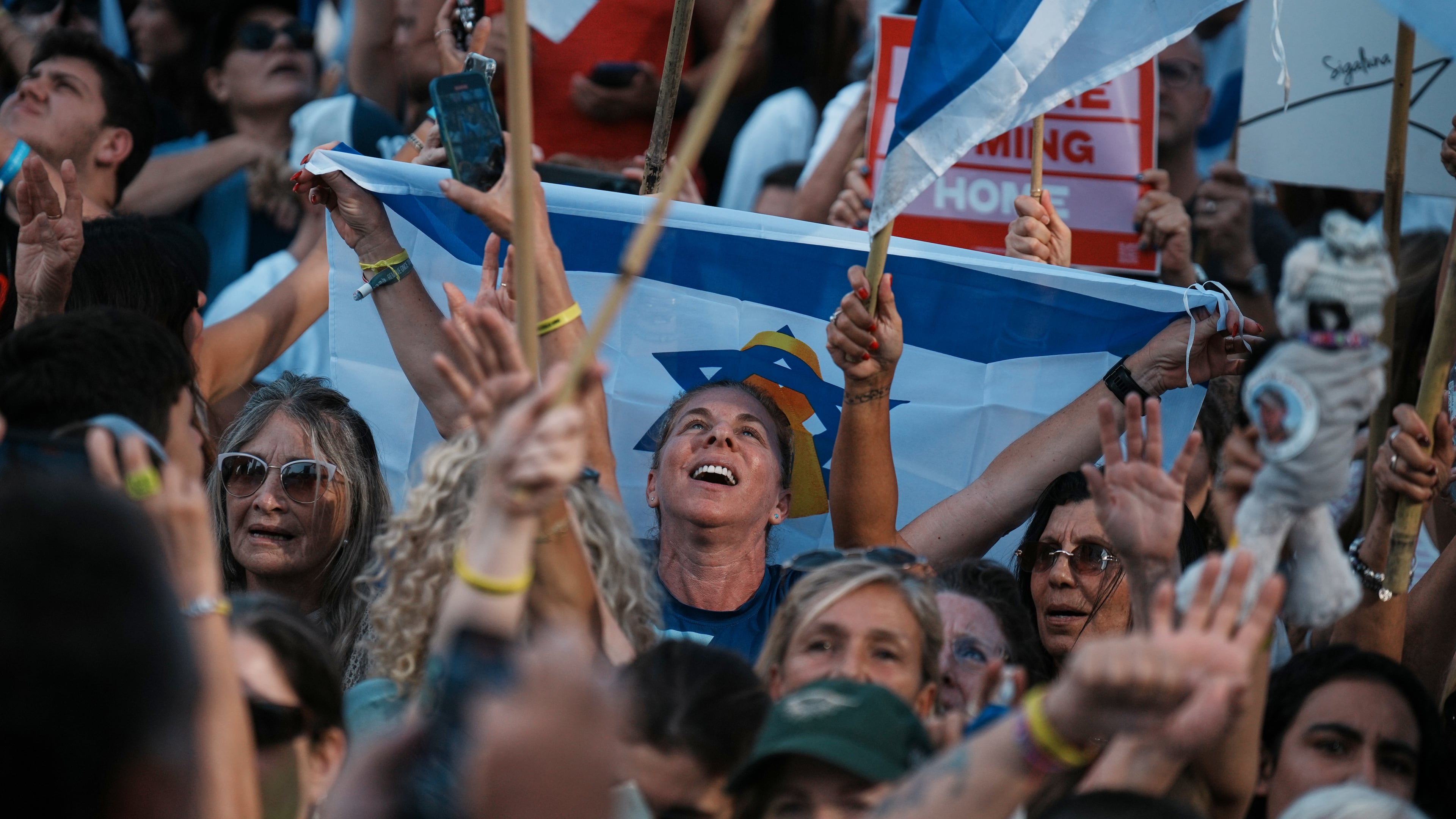 People react as they gather to watch a live broadcast of Israeli hostages released from Gaza at a plaza known as hostages square in Tel Aviv, Israel, Monday, Oct. 13, 2025. (AP Photo/Emilio Morenatti)