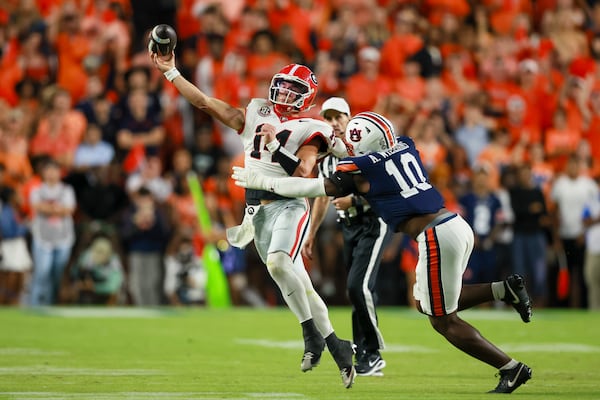 Georgia quarterback Gunner Stockton (14) attempts a pass under pressure from Auburn defensive end Amaris Williams (10) during the first half at Jordan-Hare Stadium, Saturday, October 11, 2025, in Auburn, Al. (Jason Getz / AJC)