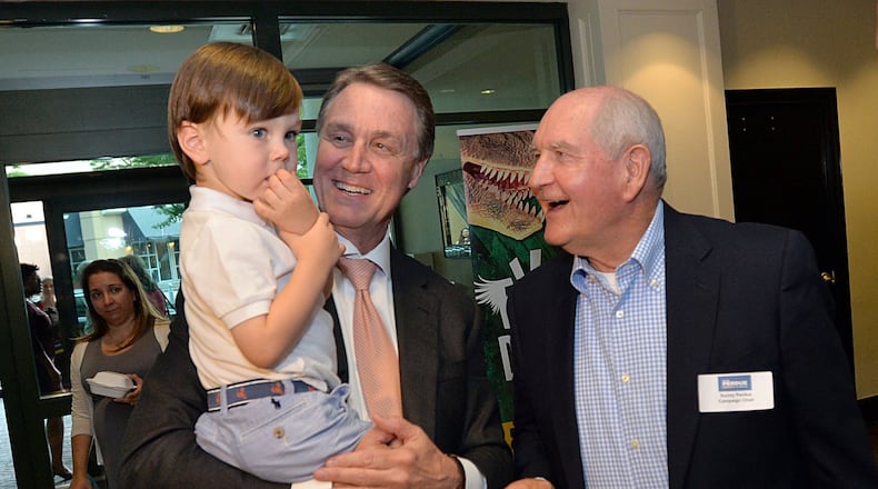 David Perdue holds his grandson, David Perdue IV, as Sonny Perdue looks on during David Perdue’s Election Night party in Buckhead in 2014. (Hyosub Shin / hshin@ajc.com)