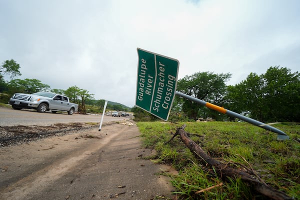 A downed sign is seen near a crossing of the Guadalupe River after a flash flood swept through the area Saturday, July 5, 2025, in Ingram. (AP Photo/Julio Cortez)