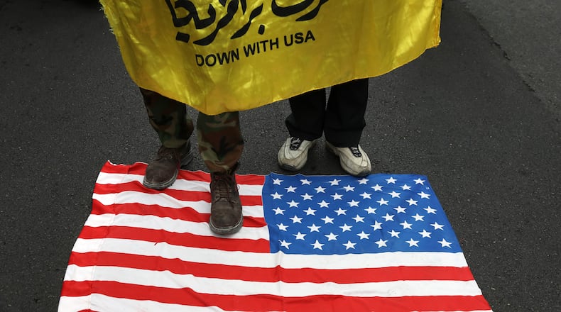 Demonstrators set fire to a rendition of the U.S. flag during a rally in front of the former U.S. Embassy in Tehran, Iran, on Monday. Reviving decades-old cries of "Death to America," Iran marked the 40th anniversary of the 1979 student takeover of the U.S. Embassy in Tehran and the 444-day hostage crisis that followed as tensions remain high over the country's collapsing nuclear deal with world powers.