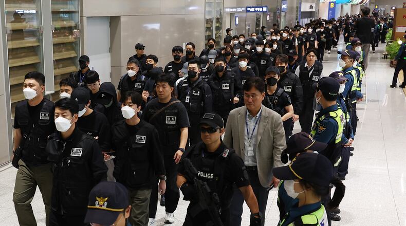 FILE - South Koreans, walking in the line to the left, who are allegedly involved in online scams in Cambodia arrive at the Incheon International Airport, in Incheon, South Korea, Oct. 18, 2025. (Yonhap via AP, File)