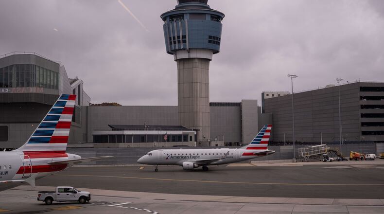 An American Eagle plane moves past the FAA Air Traffic Control tower at LaGuardia Airport (LGA) in the Queens borough of New York, Sunday, Nov. 9, 2025. (AP Photo/Adam Gray)