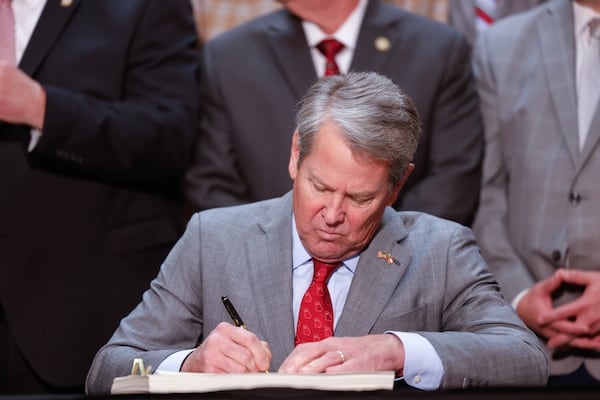 Gov. Brian Kemp signs the budget bill at the Capitol in Atlanta earlier this month. (Arvin Temkar/AJC)