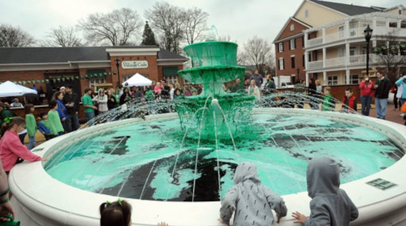 Festival goers gather at Smyrna's Market Village fountain to watch an annual "dying of the fountain, " which turns the fountain waters green.
