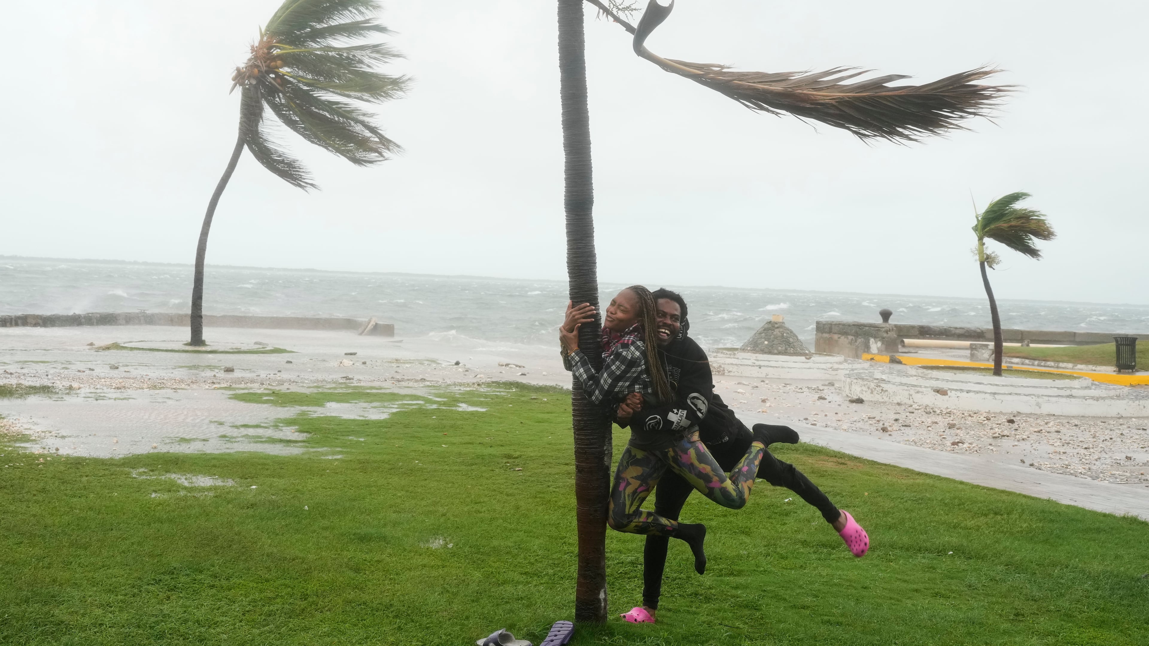 A couple jokes around on the coast in Kingston, Jamaica, as Hurricane Melissa approaches, Tuesday, Oct. 28, 2025. (AP Photo/Matias Delacroix)
