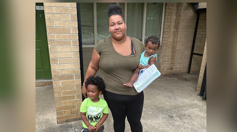 Louana Joseph with her son, M.J. (left), and her infant daughter, Marlie, outside their former apartment complex in southwestern Atlanta. Joseph moved out of the unit because she suspected the gray and brown splotches that were spreading through the unit were mold. After rents soared during the pandemic, some families were forced to live in substandard housing, which increased their risk for health problems such as asthma and lead poisoning. (Andy Miller/KHN)