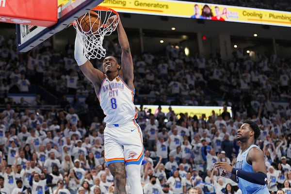 Oklahoma City Thunder forward Jalen Williams (8) dunks as Memphis Grizzlies forward Jaren Jackson Jr., right, looks on during the first half in Game 1 of an NBA first-round playoff series, Sunday, April 20, 2025, in Oklahoma City. (AP Photo/Nate Billings)