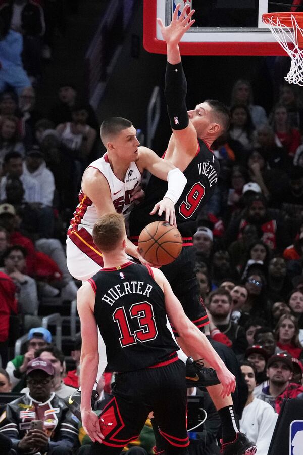 Miami Heat guard Tyler Herro, left top, drives to the basket against Chicago Bulls center Nikola Vucevic during the second half of an NBA play-in tournament basketball game in Chicago, Wednesday, April 16, 2025. (AP Photo/Nam Y. Huh)