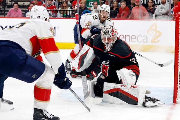 Carolina Hurricanes goaltender Pyotr Kochetkov (52) watches the puck from between Florida Panthers' A.J. Greer (10) an Matthew Tkachuk (19) during the third period of Game 2 of the NHL hockey Stanley Cup Eastern Conference finals in Raleigh, N.C., Thursday, May 22, 2025. (AP Photo/Karl DeBlaker)