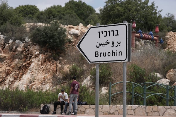 Young Israeli settlers sit outside of the West Bank settlement of Bruchin, the morning after a Palestinian gunman shooting killed Tzeela Gez, who was on her way to the hospital to give birth, outside of the settlement, Thursday, May 15, 2025. (AP Photo/Maya Alleruzzo)