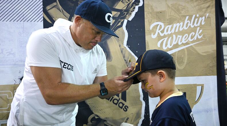 Georgia Tech coach Geoff Collins signs an autograph for A.J. Davis, 7, during First Saturday on The Flats, Georgia Tech football’s annual Fan Day event. (Hyosub Shin / Hyosub.Shin@ajc.com)
