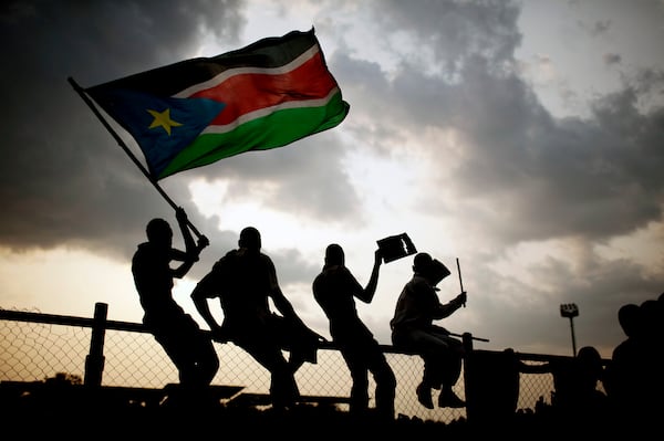 FILE - In this Sunday, July 10, 2011 file photo, Southern Sudanese wave the national flag in the capital Juba. (AP Photo/Pete Muller, File)