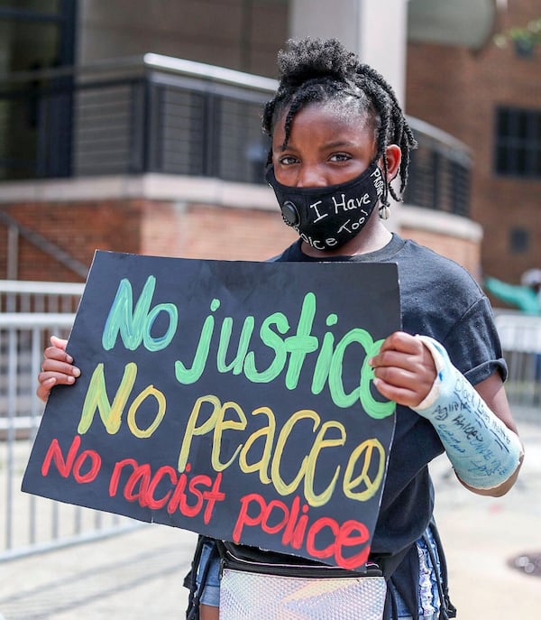 Eleven-year-old T'Kaia Veney, a demonstrator who is part of the "I have a voice too" kids rally movement, shows off her sign during a protest outside of the Atlanta City Detention Center in June. (Alyssa Pointer / alyssa.pointer@ajc.com)