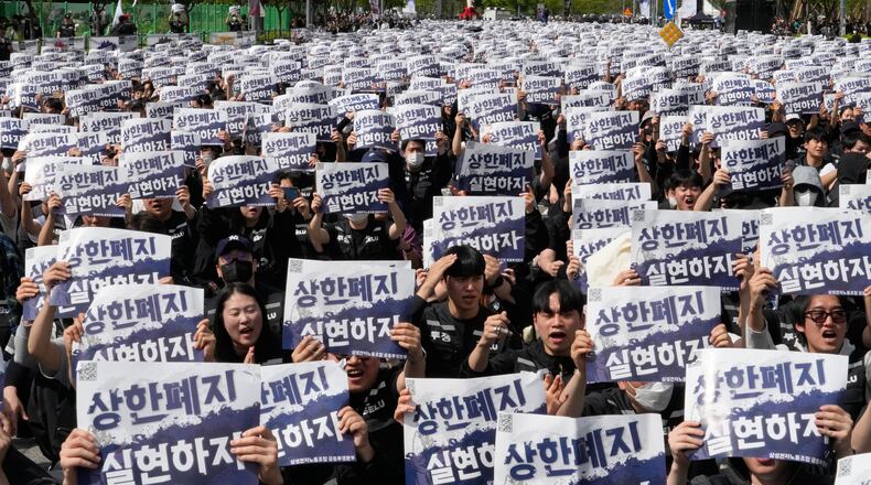 Members of the Samsung Electronics labor union hold up their cards during a rally demanding higher bonuses at its computer chip complex in Pyeongtaek, South Korea, Thursday, April 23, 2026. The letters read "Remove the bonuses caps." (AP Photo/Ahn Young-joon)