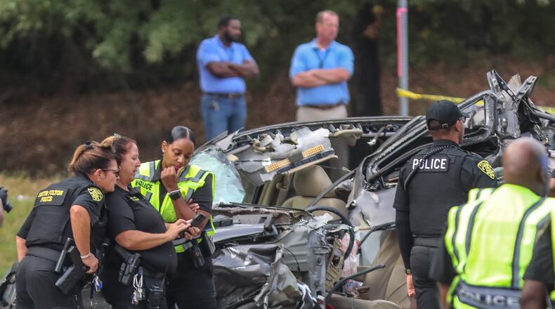 South Fulton police officers investigate a deadly crash on Fulton Industrial Boulevard last October. Georgia public safety officials say that if you're in a wreck, often the safest place to stay is in your car. (John Spink / John.Spink@ajc.com)